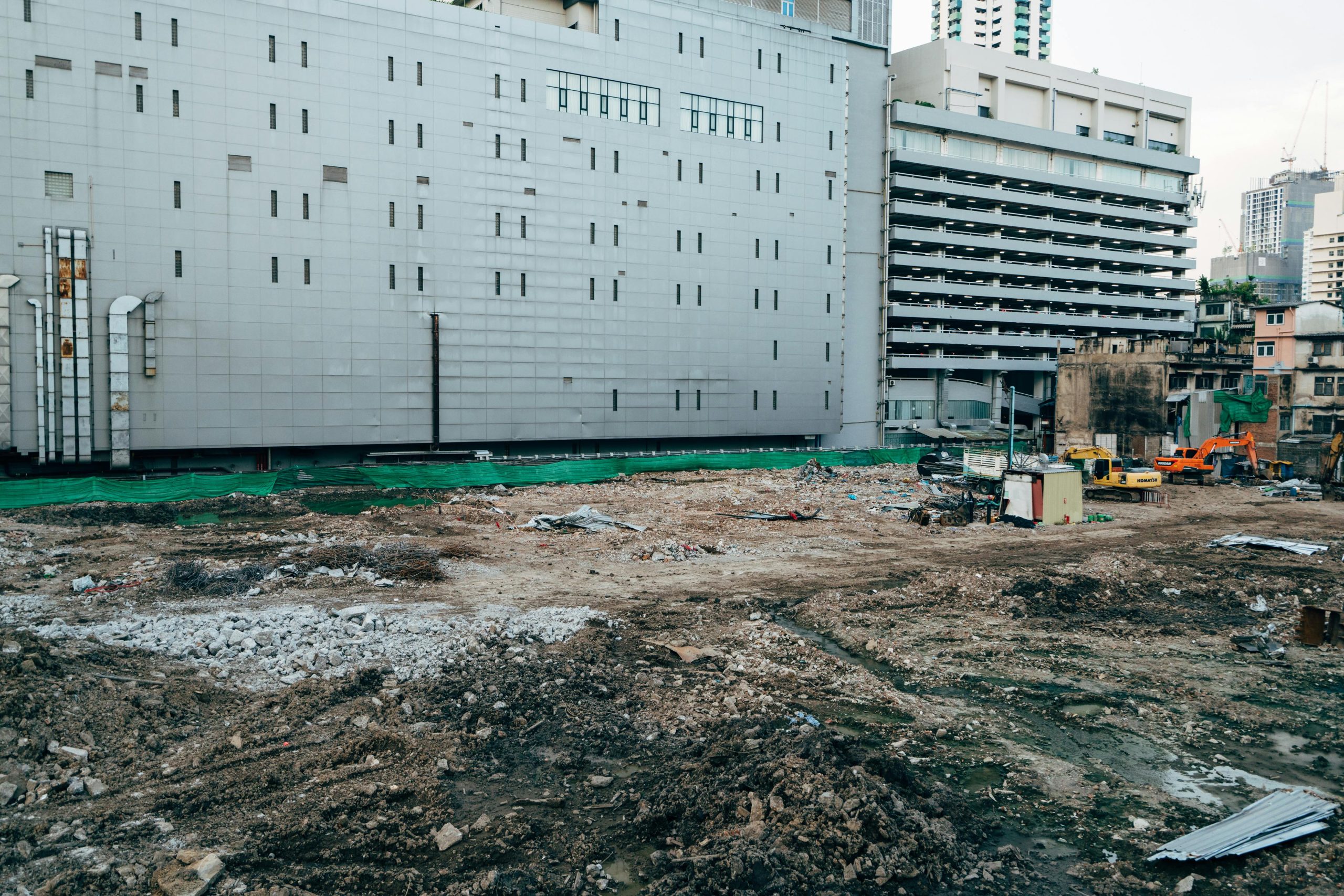 A construction site with surrounding modern buildings in an urban setting.